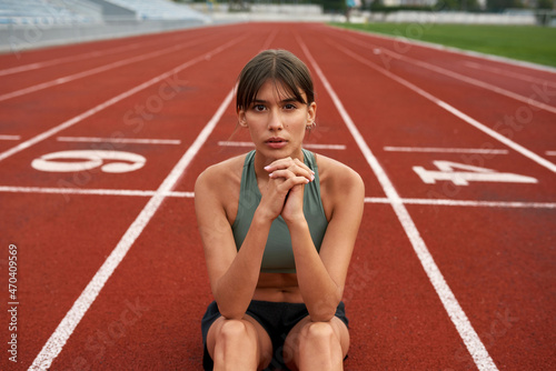 Confident sports woman sit on stadium treadmill