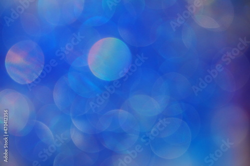 Bokeh circles of light on dark blue tone background, space for advertising copy.
