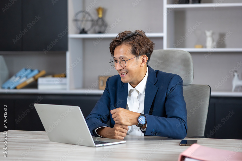 Middle aged asian man exclusive making video call conference meeting in modern home office. Middle aged asian man exclusive making video call conference meeting in modern home office.