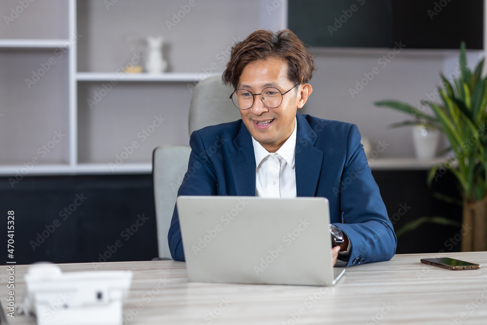 Middle aged asian man exclusive making video call conference meeting in modern home office. Middle aged asian man exclusive making video call conference meeting in modern home office.