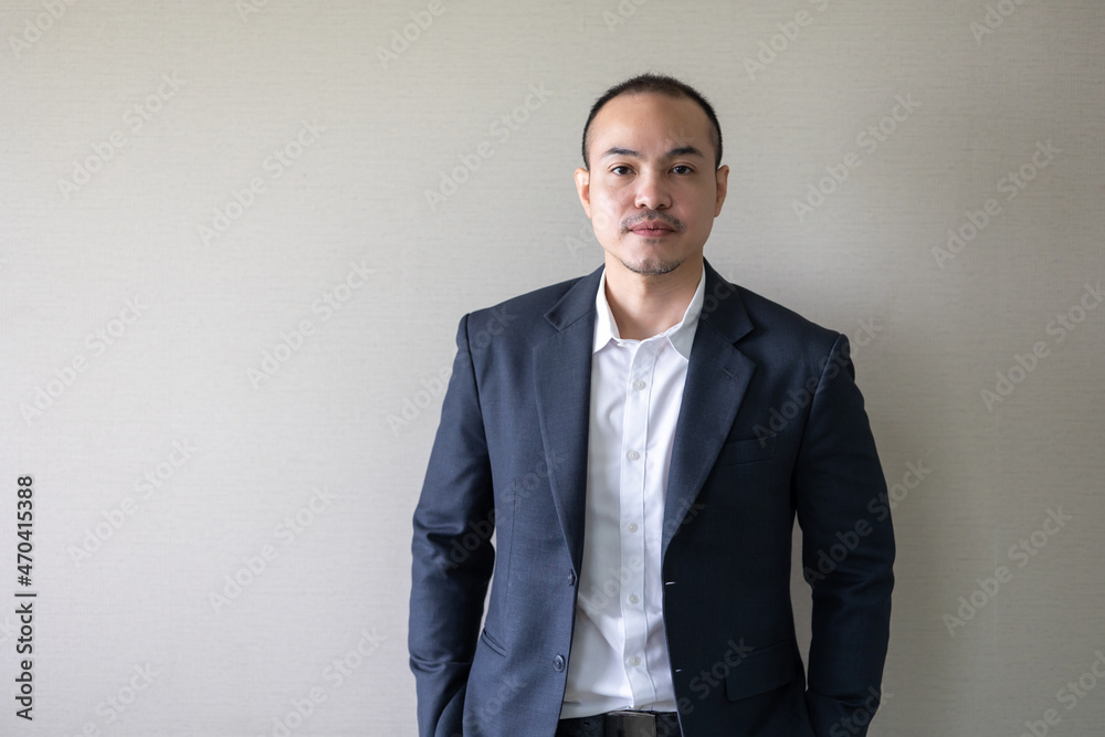 Portrait Asian business man standing look at camera in modern office. Close up face of businessman smiling Portrait Asian business man standing look at camera in modern office. Close up face of businessman smiling