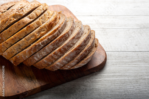 Sliced sourdough bread on wooden chopping board.