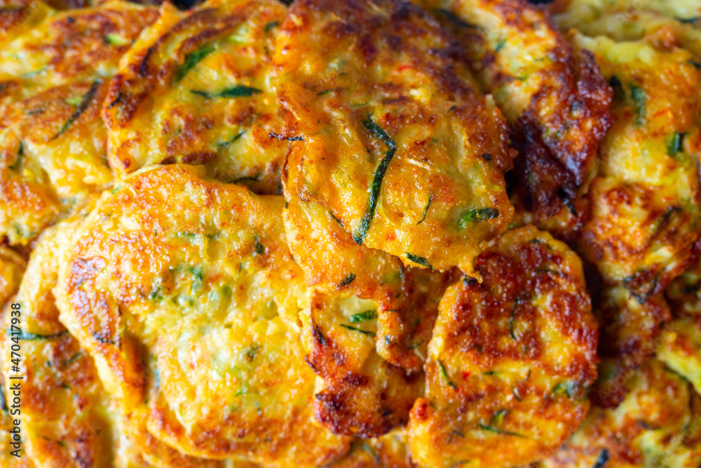 Close-up of pancakes made of zucchini and vegetables. A delicious vegetarian dish. Top view, flat lay, food background Close-up of pancakes made of zucchini and vegetables. A delicious vegetarian dish. Top view, flat lay, food background