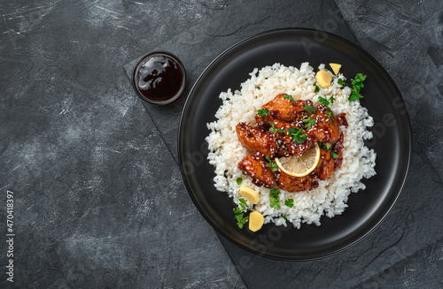 Japanese teriyaki chicken with rice on a dark background.