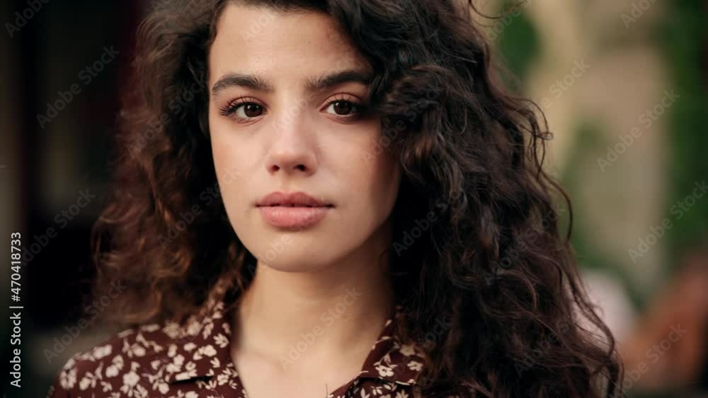 Close-up portrait of smiling girl looking at. Curly hair fashion model face smiling. Portrait of joyful girl open eyes. Female nature beauty