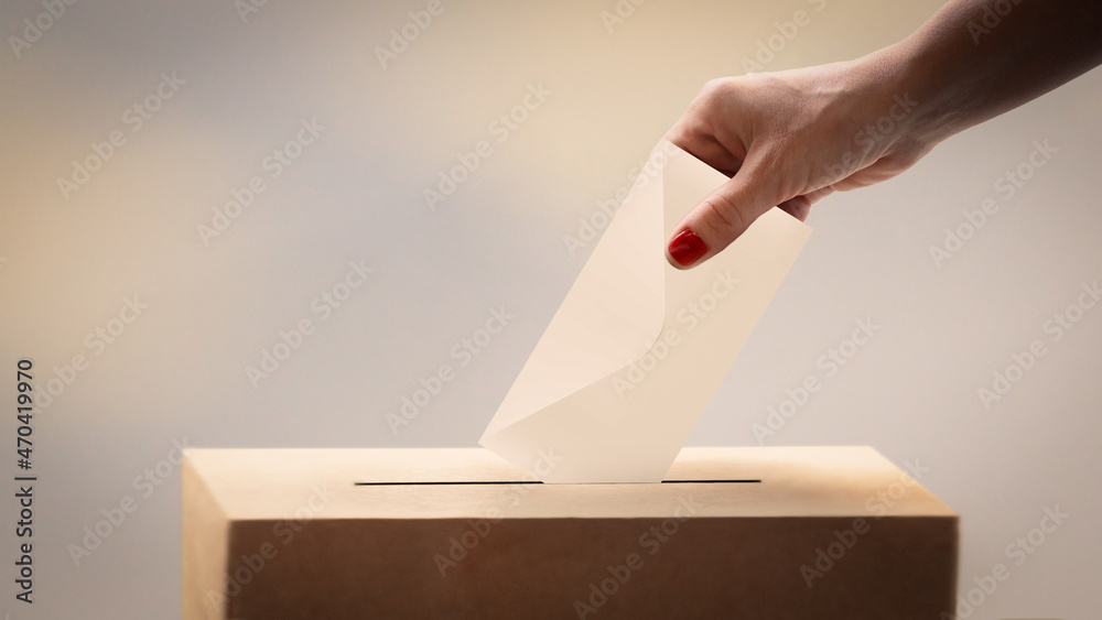 choice concept. Female voter throwing her ballot at the ballot box choice concept. Female voter throwing her ballot at the ballot box