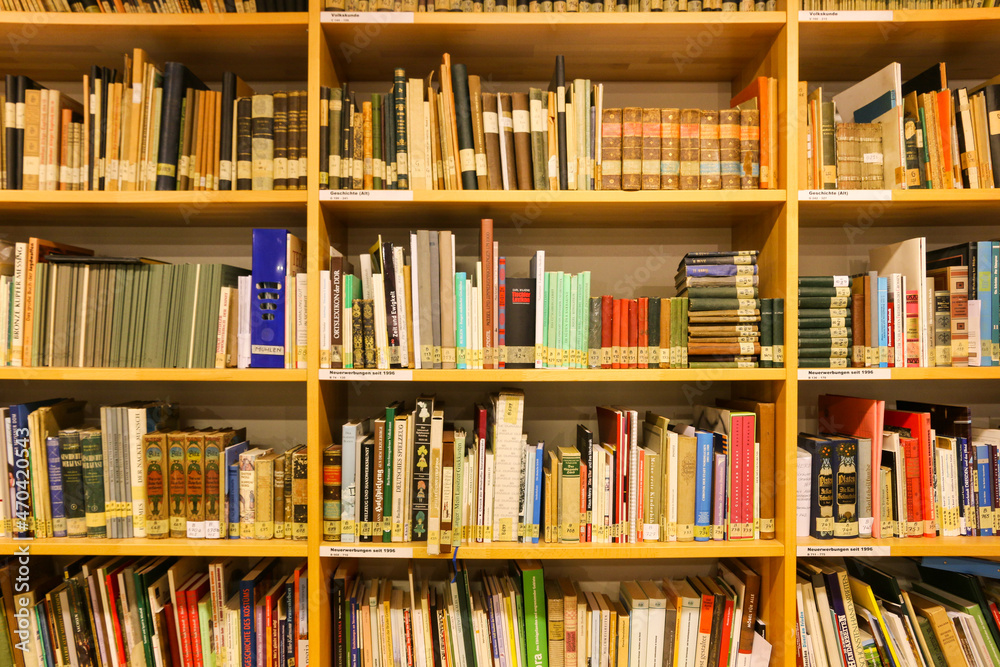 Bunt gemischtes Bücheregal als Bücherwand mit alten und neuen Büchern in verschiedenen Größen Bunt gemischtes Bücheregal als Bücherwand mit alten und neuen Büchern in verschiedenen Größen