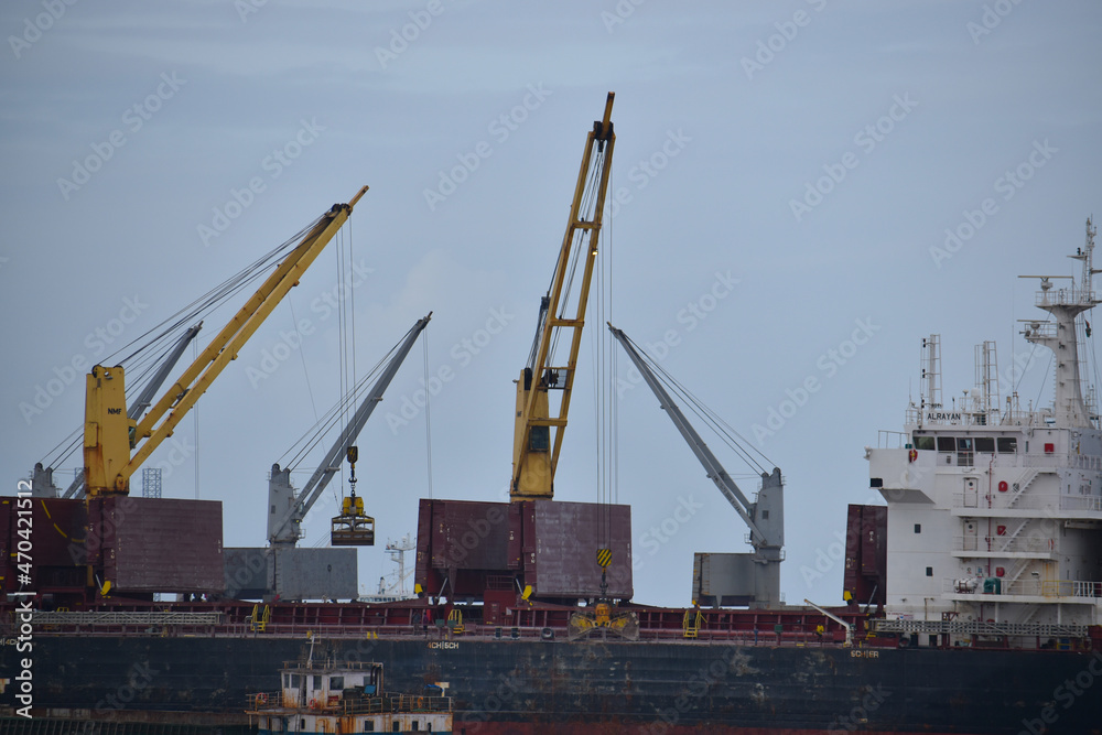 India 18 november 2021 .Loading goods on cargo ship with crane. Shipment from a merchant to a small ship
