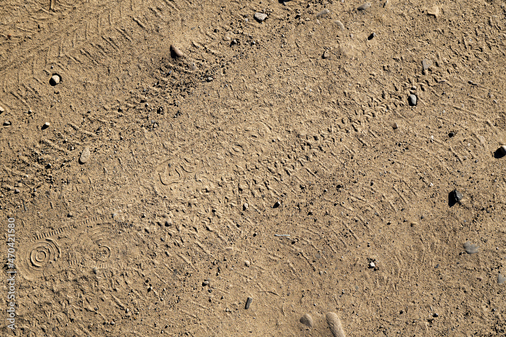 Natural sand stone texture background. Sand texture from heap of sand. Traces of the protectors of heavy industrial machinery on white sand. Background. Natural sand stone texture background. Sand texture from heap of sand. Traces of the protectors of heavy industrial machinery on white sand. Background.
