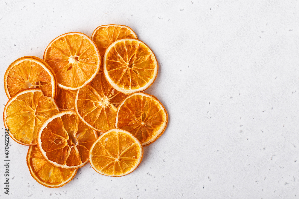 Dried sliced orange, fruits chips on white stone background, home drying. Snack vegan free sugar food, space for text Dried sliced orange, fruits chips on white stone background, home drying. Snack vegan free sugar food, space for text