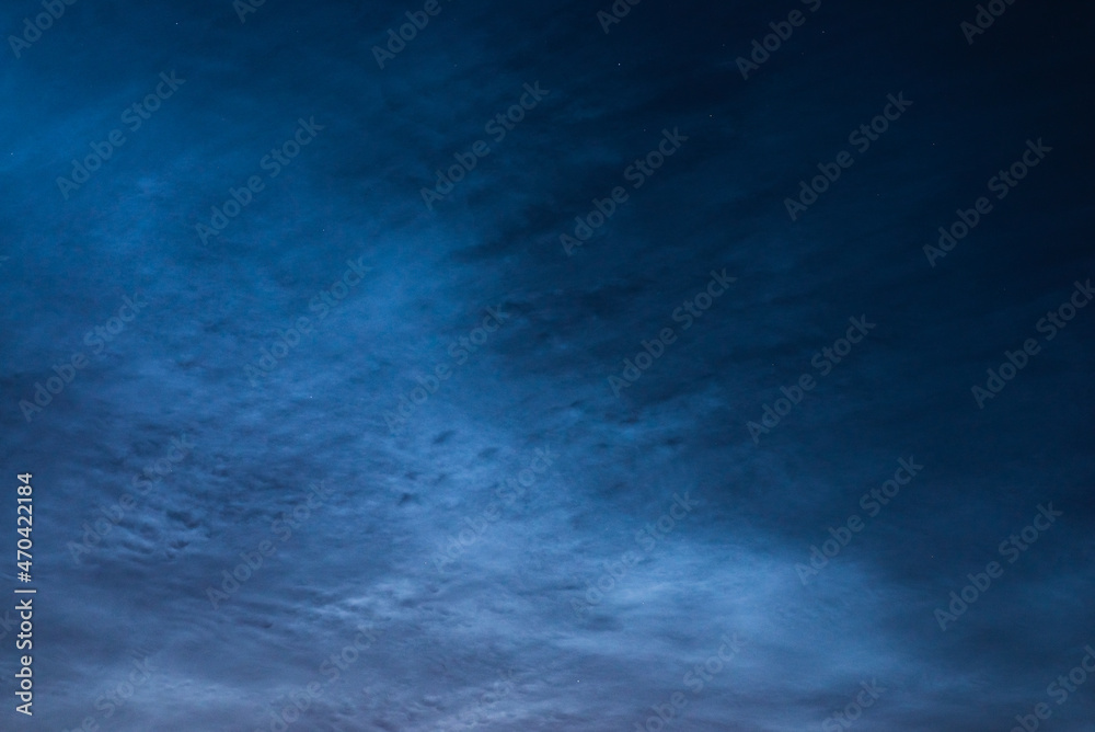 Noctilucent clouds close up on a summer night. Glowing clouds in the night sky.