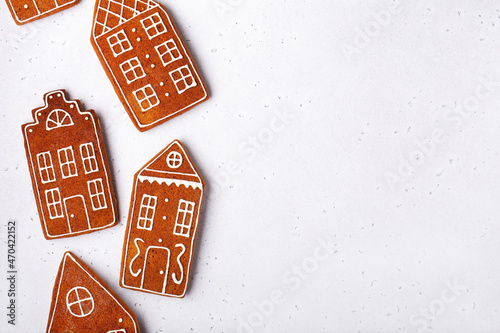 gingerbread cookies in the shape of houses on a white stone background, horizontally, a place for text, new year,christmas