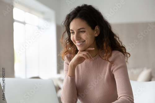 Free Download Head shot smiling hispanic businesswoman looking at laptop screen, working or studying online, excited satisfied young female chatting in social networks, watching video or movie, sitting at desk - GFXLoad