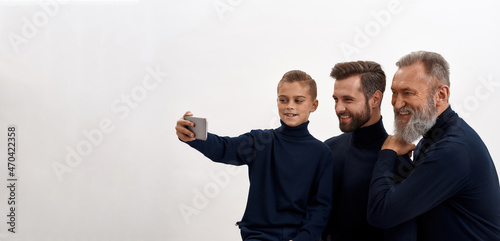 Wide shot of three male generations make selfie