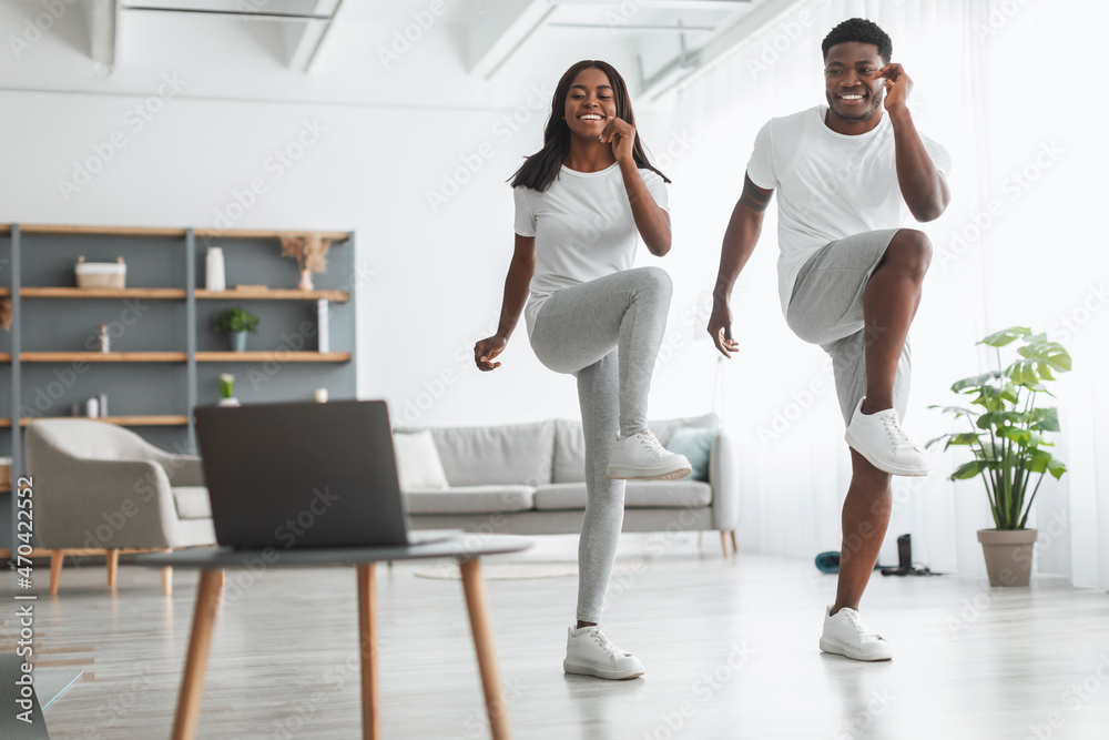 Young black couple doing cross knee to elbow exercise