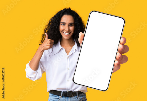 Cute pretty midde-eastern woman showing mobile phone with empty screen © Prostock-studio
