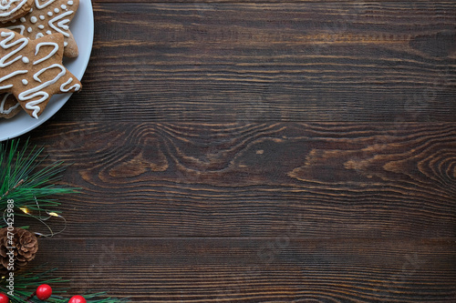 Christmas background with gingerbread cookies on a plate and wooden brown texture