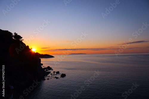 An amazing caption of the sunset in winter days over the sea of Genova with beautiful red sky and some amazing clouds in the background