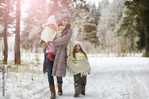 Happy family playing and laughing in winter outdoors in the snow. City park winter day.