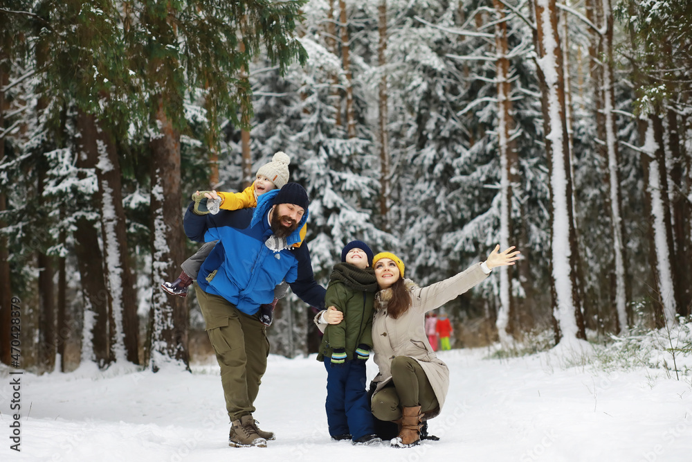 Happy family playing and laughing in winter outdoors in the snow. City park winter day.