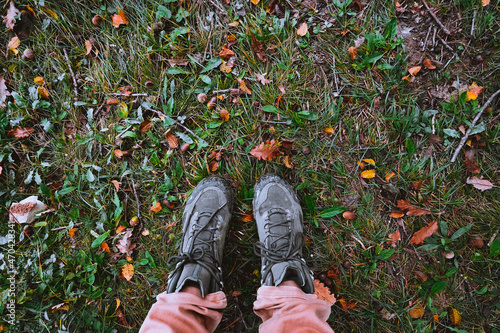 Foot selfie on Dry yellow leaves and acorns on wet grass. Autumn travel