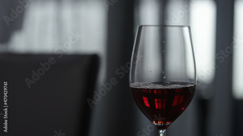 red wine in wineglass indoor with window on background