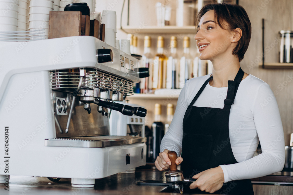 Woman barista at a coffee shop preparing coffee Woman barista at a coffee shop preparing coffee