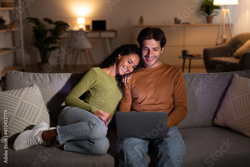 Young Spouses Watching Film Online On Laptop Relaxing At Home