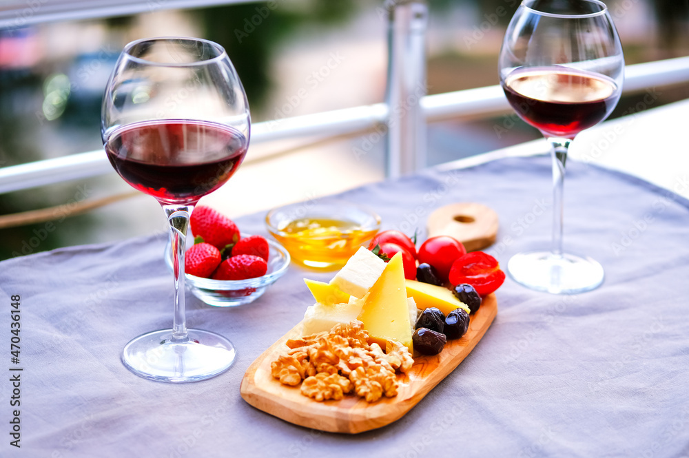 Naklejka premium Two glasses of wine and cheese plate. Aperitif.