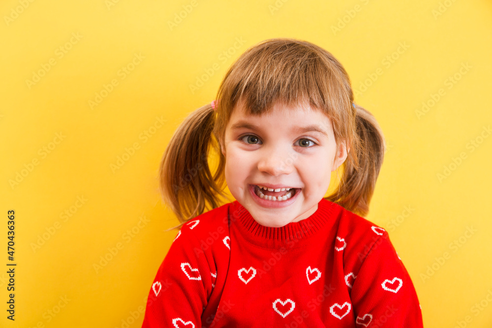 portrait of a laughing child girl in a red sweater on a yellow background. place for text.
portrait of a laughing child girl in a red sweater on a yellow background. place for text.