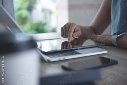 Closeup, business woman finger signing on digital tablet, online working on laptop computer at home office, E-signing