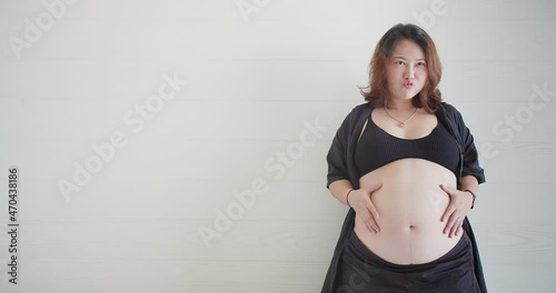 Portrait attractive happy Asian pregnant woman standing touching her big belly with love, pregnancy, motherhood, people and expectation concept photo
