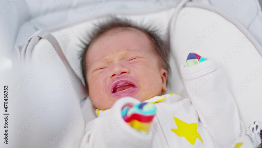 Crying Newborn baby boy lying on white bed at home.Infant baby screaming very hungry or stomach pain.Tired baby crying concept Crying Newborn baby boy lying on white bed at home.Infant baby screaming very hungry or stomach pain.Tired baby crying concept