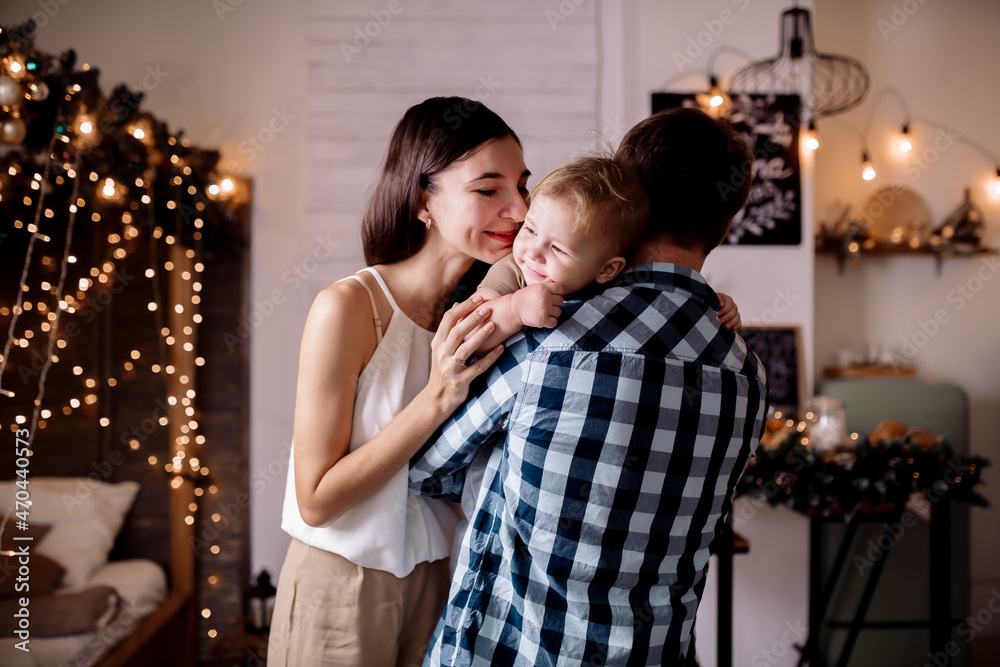 Young family playing with children in room decorated for christmas Young family playing with children in room decorated for christmas