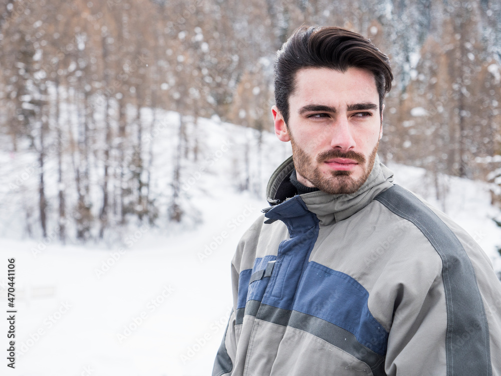 Handsome man standing in snow with ski suit Handsome man standing in snow with ski suit