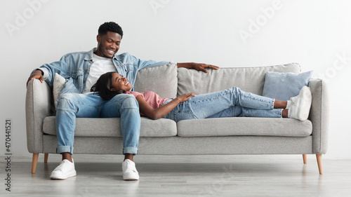 African american couple spending weekend together lying on couch © Prostock-studio