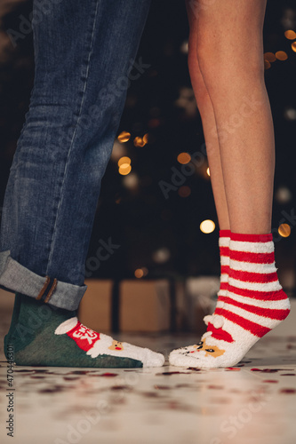 Couple standing near Christmas tree wearing warm socks