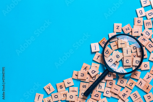 English alphabet made of square wooden tiles with the English alphabet scattered on blue background. The concept of thinking development, grammar. photo