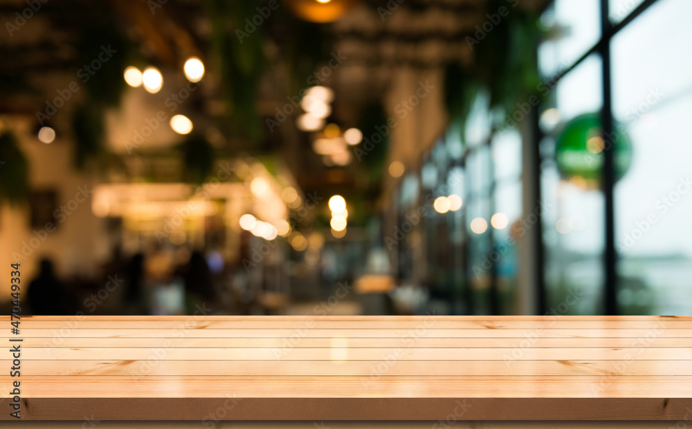 Empty wooden table top with lights bokeh on blur restaurant background. Empty wooden table top with lights bokeh on blur restaurant background.
