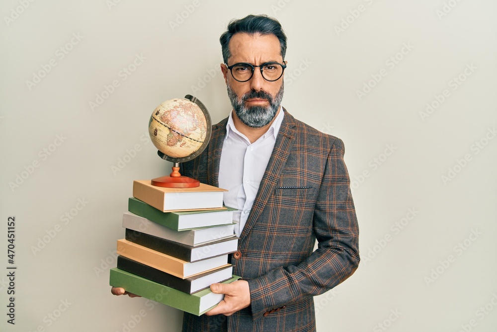 Middle age man with beard and grey hair teacher holding vintage world ball skeptic and nervous, frowning upset because of problem. negative person. Middle age man with beard and grey hair teacher holding vintage world ball skeptic and nervous, frowning upset because of problem. negative person.