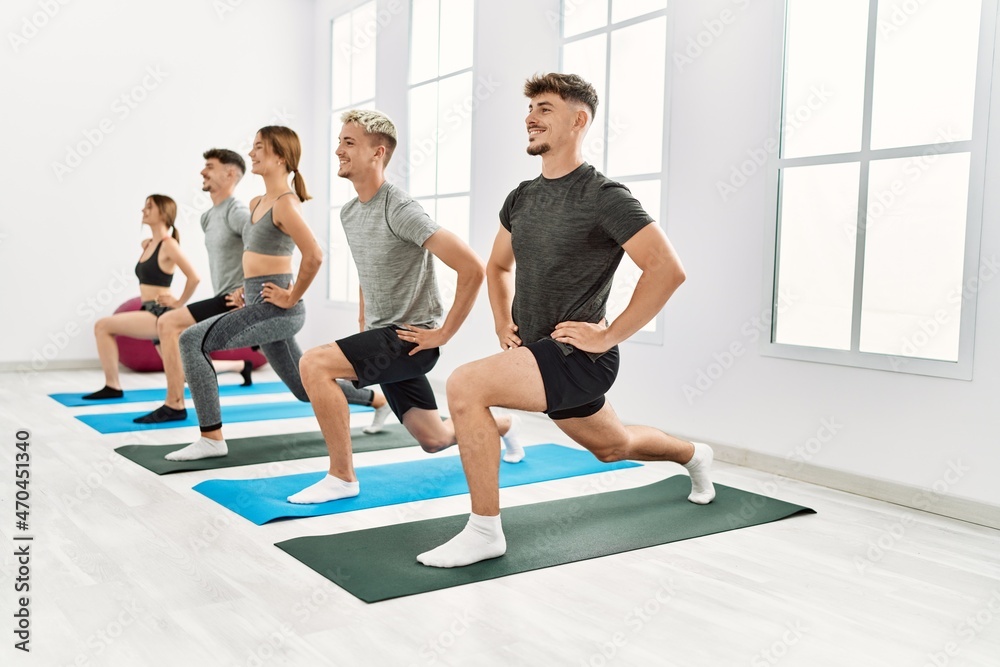 Group of young hispanic people smiling happy training legs exercise at sport center. Group of young hispanic people smiling happy training legs exercise at sport center.