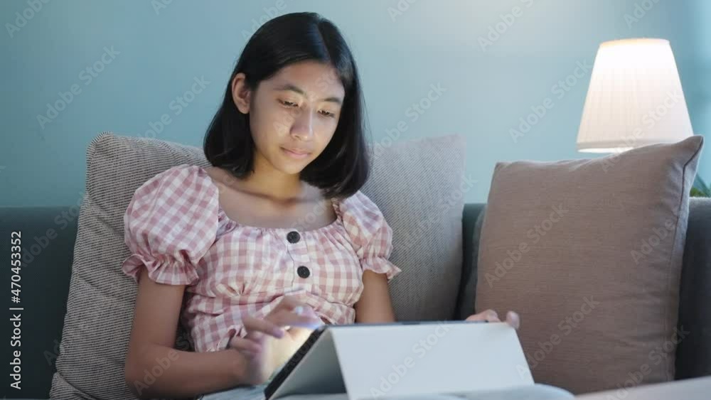 Asian woman drawing on tablet using digital pen at home night Asian woman drawing on tablet using digital pen at home night