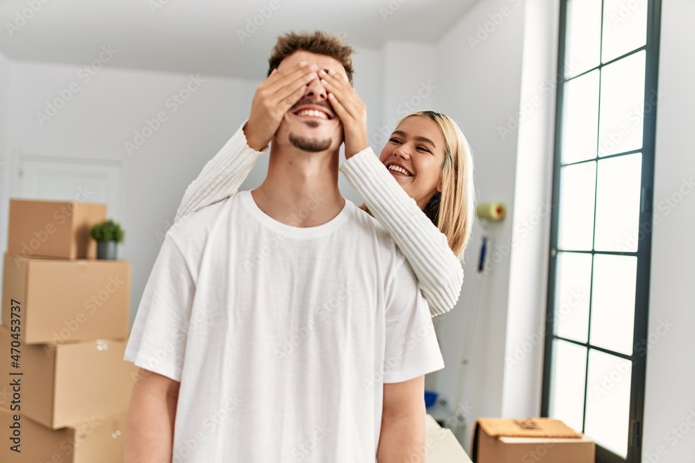Woman surprising her boyfriend covering eyes with hands at new home. Woman surprising her boyfriend covering eyes with hands at new home.