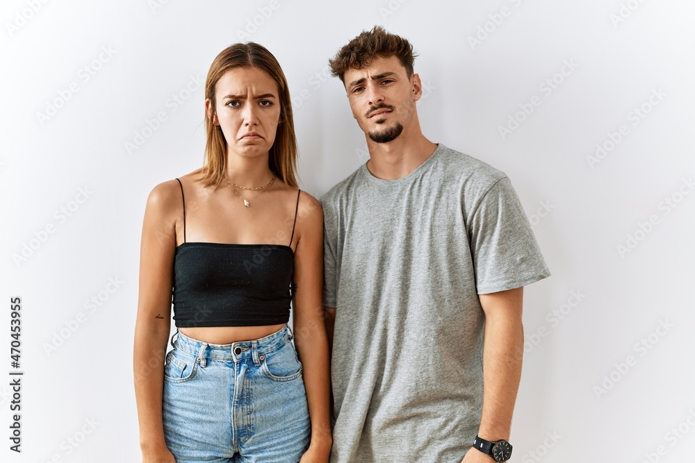 Naklejka premium Young beautiful couple standing together over isolated background depressed and worry for distress, crying angry and afraid. sad expression.