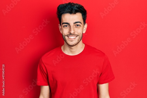 Young hispanic man wearing casual clothes looking positive and happy standing and smiling with a confident smile showing teeth