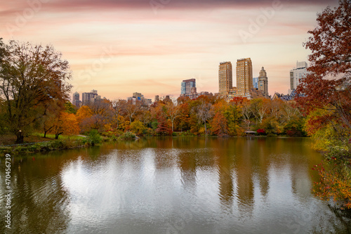 Skyline reflected in water in Central Park, NYC, surrounded by brilliant fall foliage