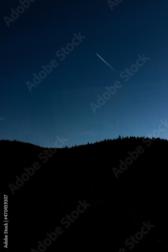 An airplane flying over the forest at night