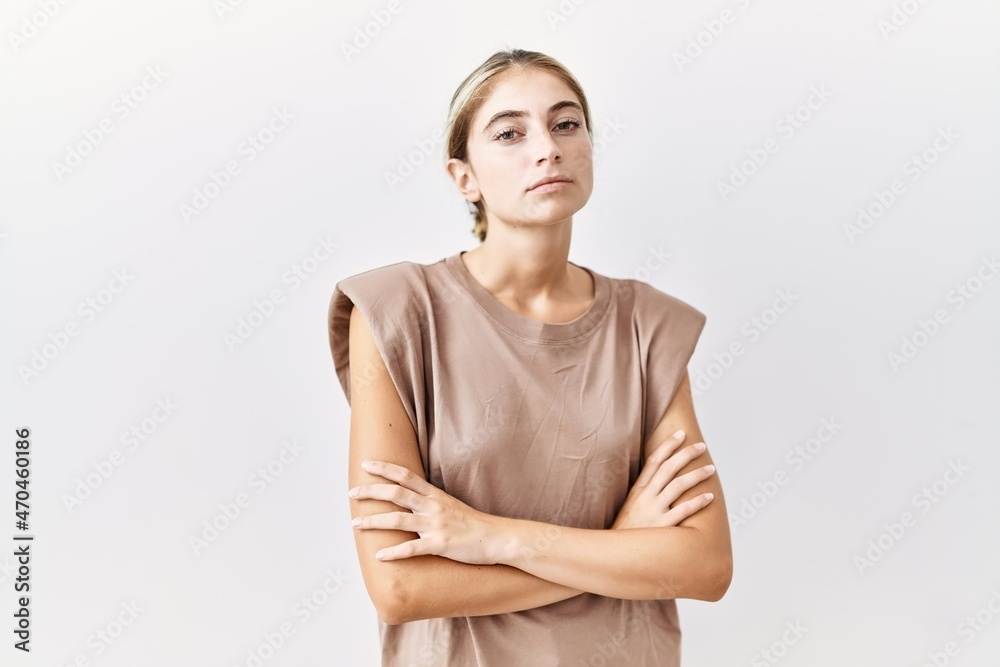 Obraz premium Young blonde woman standing over isolated background skeptic and nervous, disapproving expression on face with crossed arms. negative person.