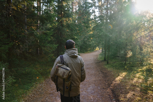 A man traveler walks through the woods. Beautiful wild nature landscape in forest. Hiking journey on tourist trail. Outdoor adventure. Travel and exploration. Healthy lifestyle, leisure activities © Iuliia Pilipeichenko