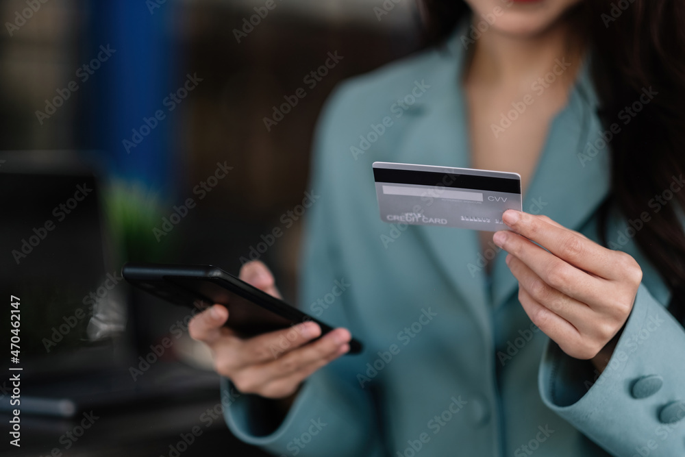 Close up woman in a cafe shopping online with credit card and mobile phone Close up woman in a cafe shopping online with credit card and mobile phone